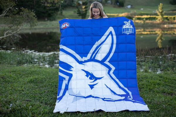 Blue and white puffy blanket with North Melbourne Kangaroos AFL logo and roo head design, quilted construction.