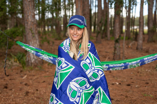 Warriors NRL blue and green sustainable down puffy blanket wrapped around person outdoors