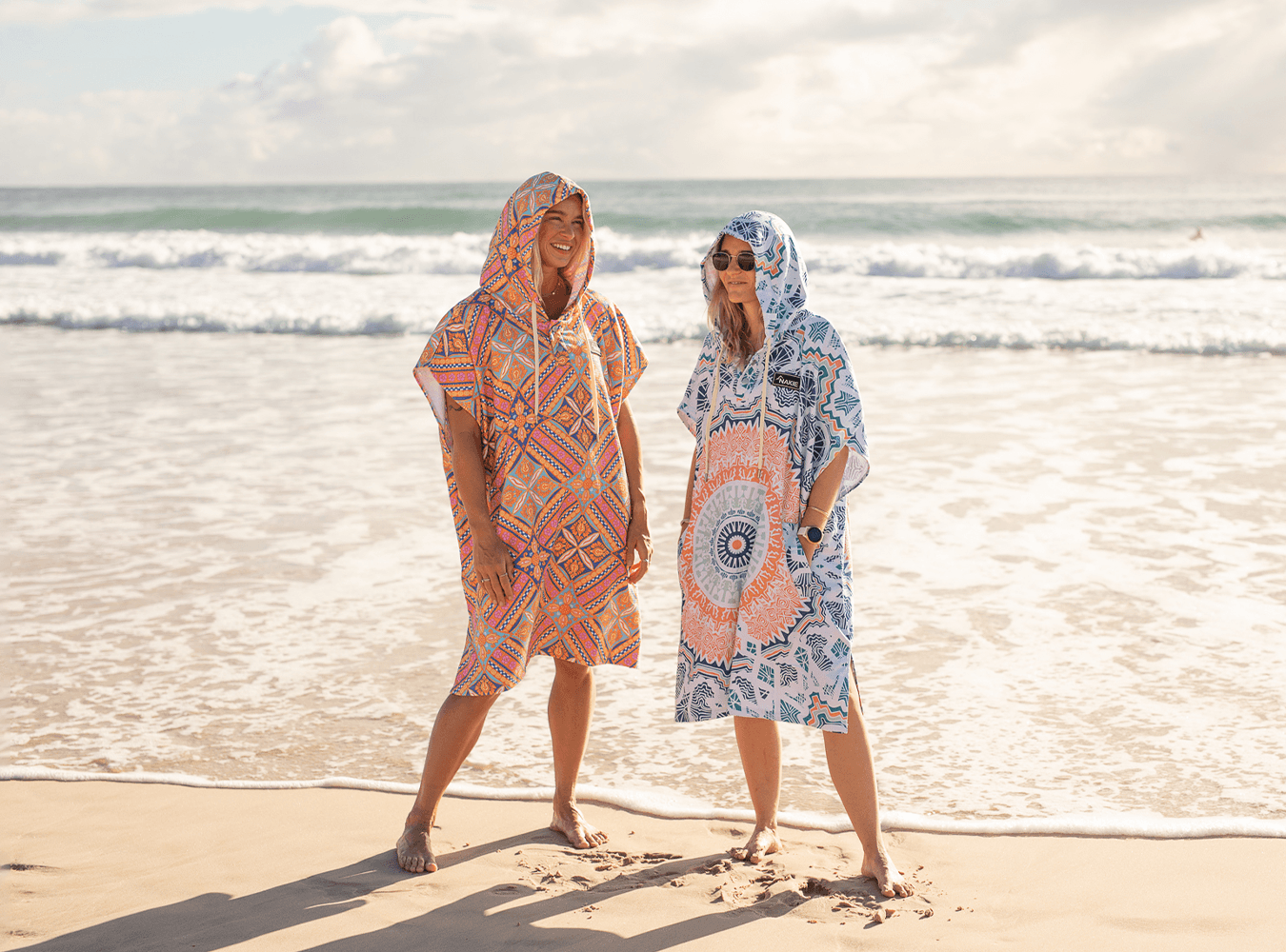 Woman in pink hooded towel on a beach