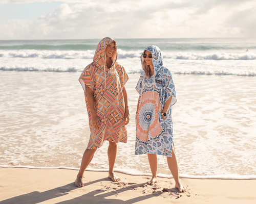 Woman in pink hooded towel on a beach