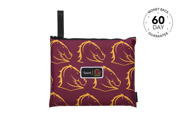 Burgundy and gold horse head patterned beach towel with black carry handle and Nakie branding label