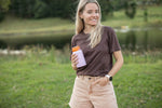 Dusty pink insulated coffee cup with orange lid, held by woman wearing brown t-shirt outdoors preview #2