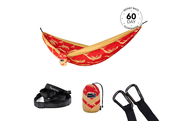Red and gold banana-pattern hammock with tan straps, displayed with black carabiners and carry bag