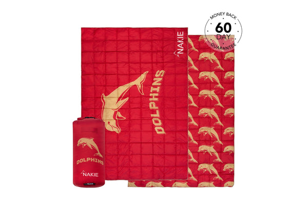 Red quilted puffy blanket with tan dolphin pattern and DOLPHINS text, shown with matching storage bag.