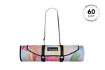 Rolled picnic blanket with multicolored floral print, black straps, and Nakie logo label, front view. preview #3