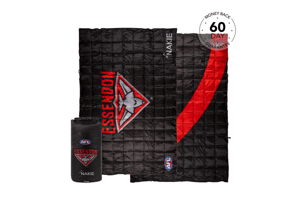 Black quilted puffy blanket with red Essendon Bombers logo and stripe, includes stuff sack, displayed flat.