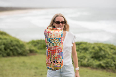 Retro Shores sustainable down puffy blanket with multicolored geometric and seaside-inspired pattern, rolled display.
