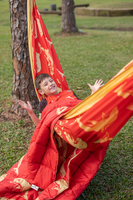 Child relaxing in eco-friendly Nakie NRL Dolphins hammock in the park