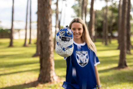 Woman in NRL Bulldogs gear showing Nakie Bulldogs Hammock in its stuff-sack.