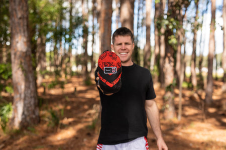 Man holding a NRL Dragons Hammock packed away into its stuff-sack for easy storage