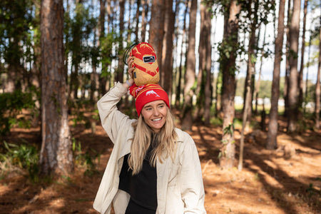 Woman in beanie holding NRL Nakie Dolphins Hammock packed in its stuff sack