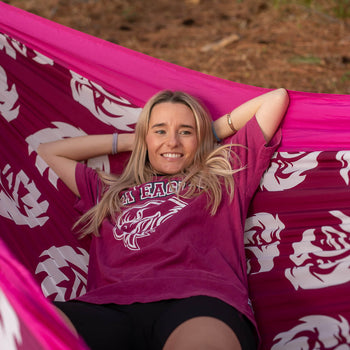Woman wearing NRL merch laying in Manly Sea Eagle NRL Nakie Hammock 