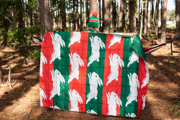 Rabbitohs quilted puffy blanket with red, green, and white striped rabbit design, shown draped outdoors.