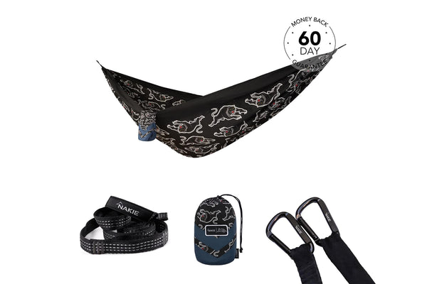 Black camping hammock with white dog outline pattern, shown hung with matching straps and carabiners included