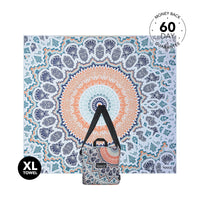 XL beach towel with blue, orange, and cream mandala pattern, shown flat with carrying pouch attached below.