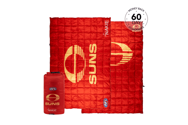 Red quilted puffy blanket with gold Gold Coast SUNS AFL logo and text, shown open with matching red compression bag.