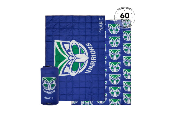 Blue quilted Warriors puffy blanket with green and white logo, shown with matching carrying pouch